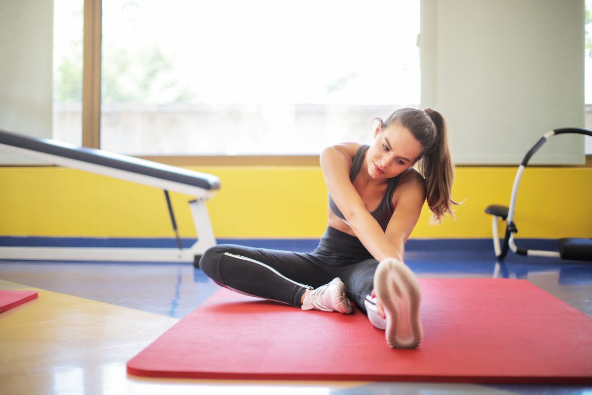 A woman stretches on an exercise mat.
