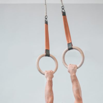 Closeup of a person's arms holding onto sports rings