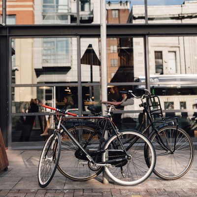 Bikes locked to a post outside a bar