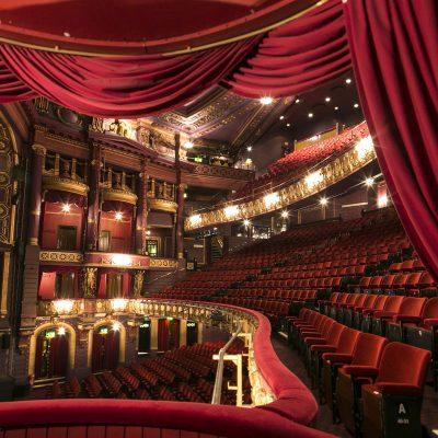 Empty theatre, with red velvet seats and curtains