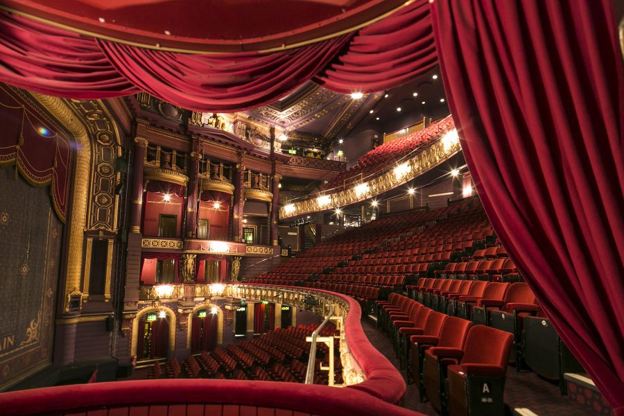 Empty theatre, with red velvet seats and curtains