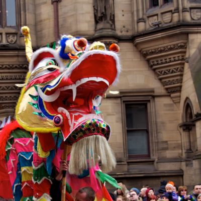 Chinese dragon puppet walks in front of crowd