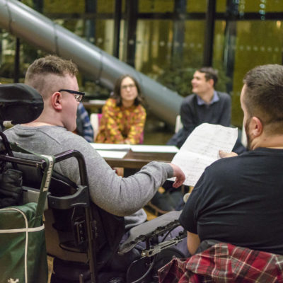 A group of young people at a workshop learning about music and songwriting.