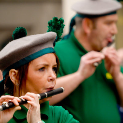 A lady plays an Irish flute in the Manchester Irish Parade.