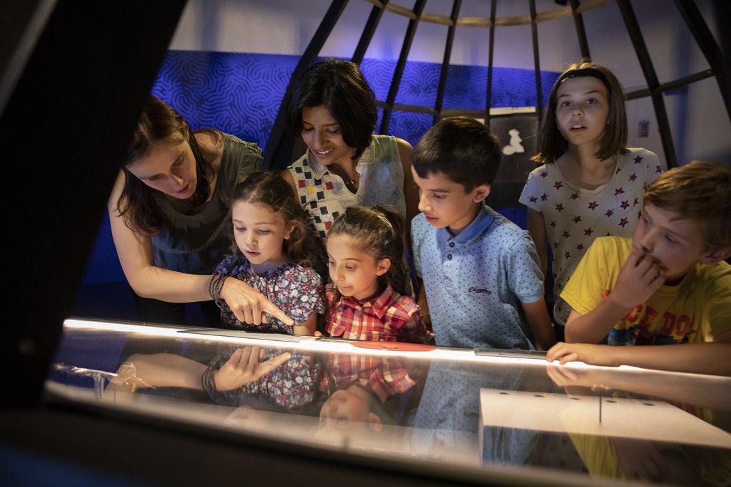 A family with young children look fascinated by an exhibition.