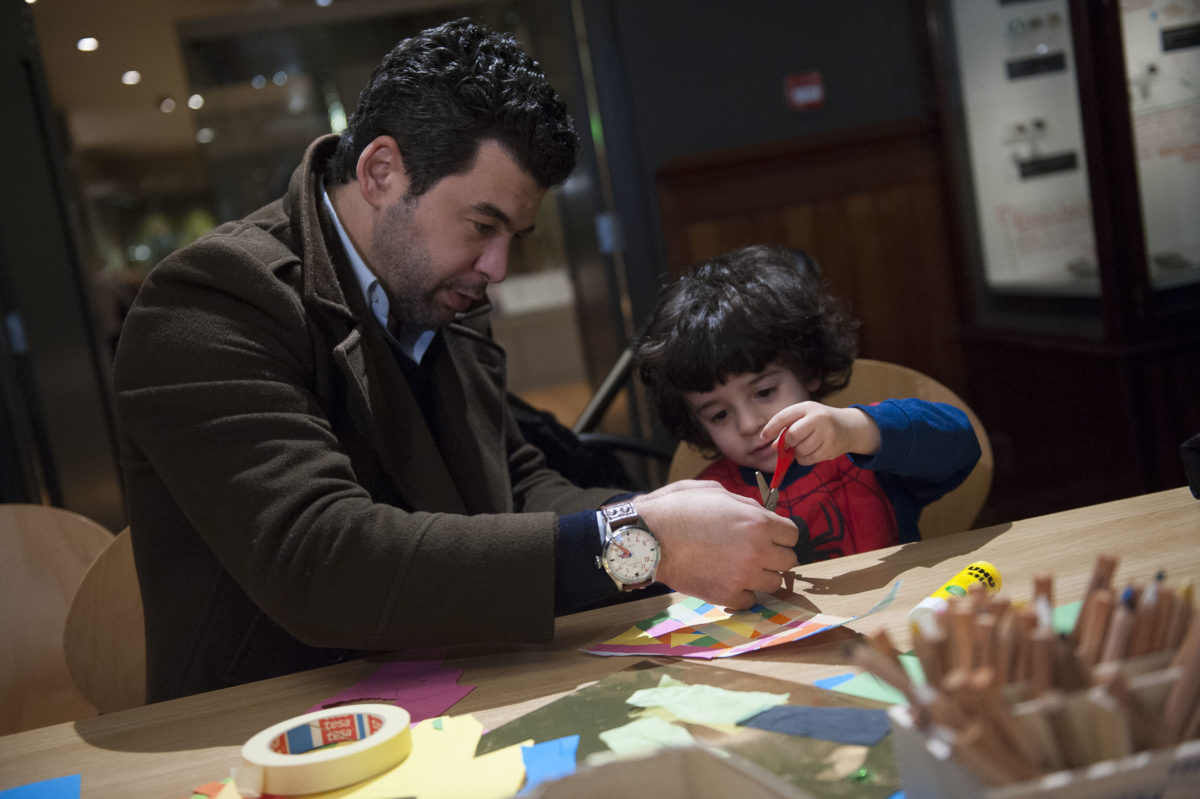 A Child and an adult enjoying a craft activity in the Manchester Museum.
