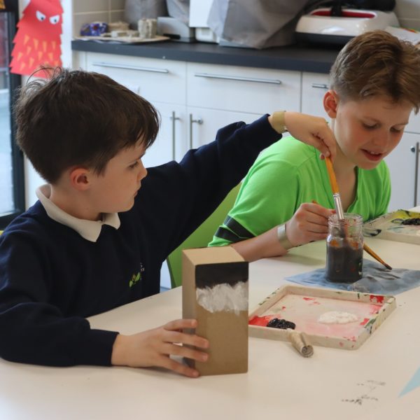 Two children enjoy an arts and crafts activity together.