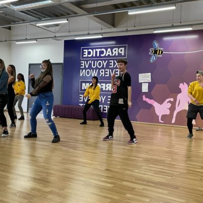 A group of young people enjoy a dance session in a fitness studio.