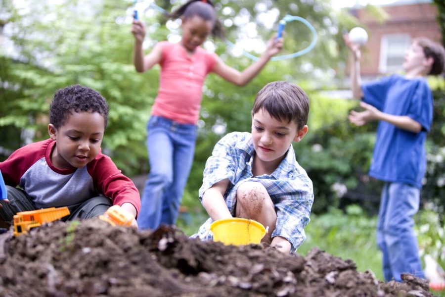 a group of young children enjoy playing outside.