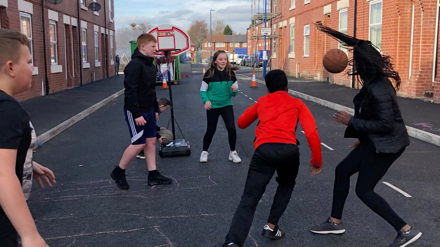 Youngsters playing sports together on Bakewell Street in Gorton, Manchester.