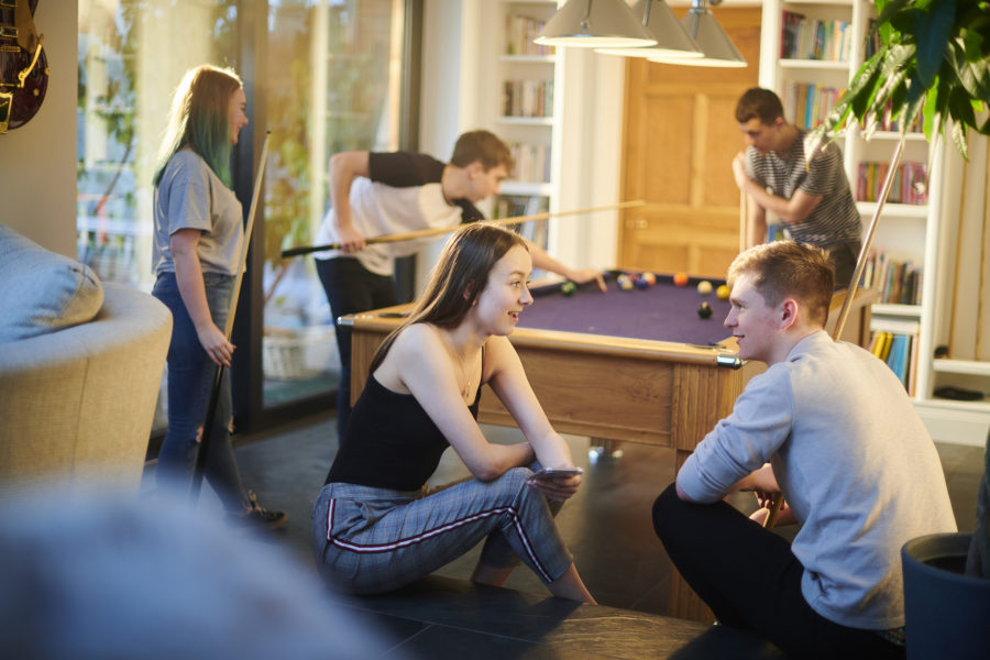 A group of teenage friends playing pool.