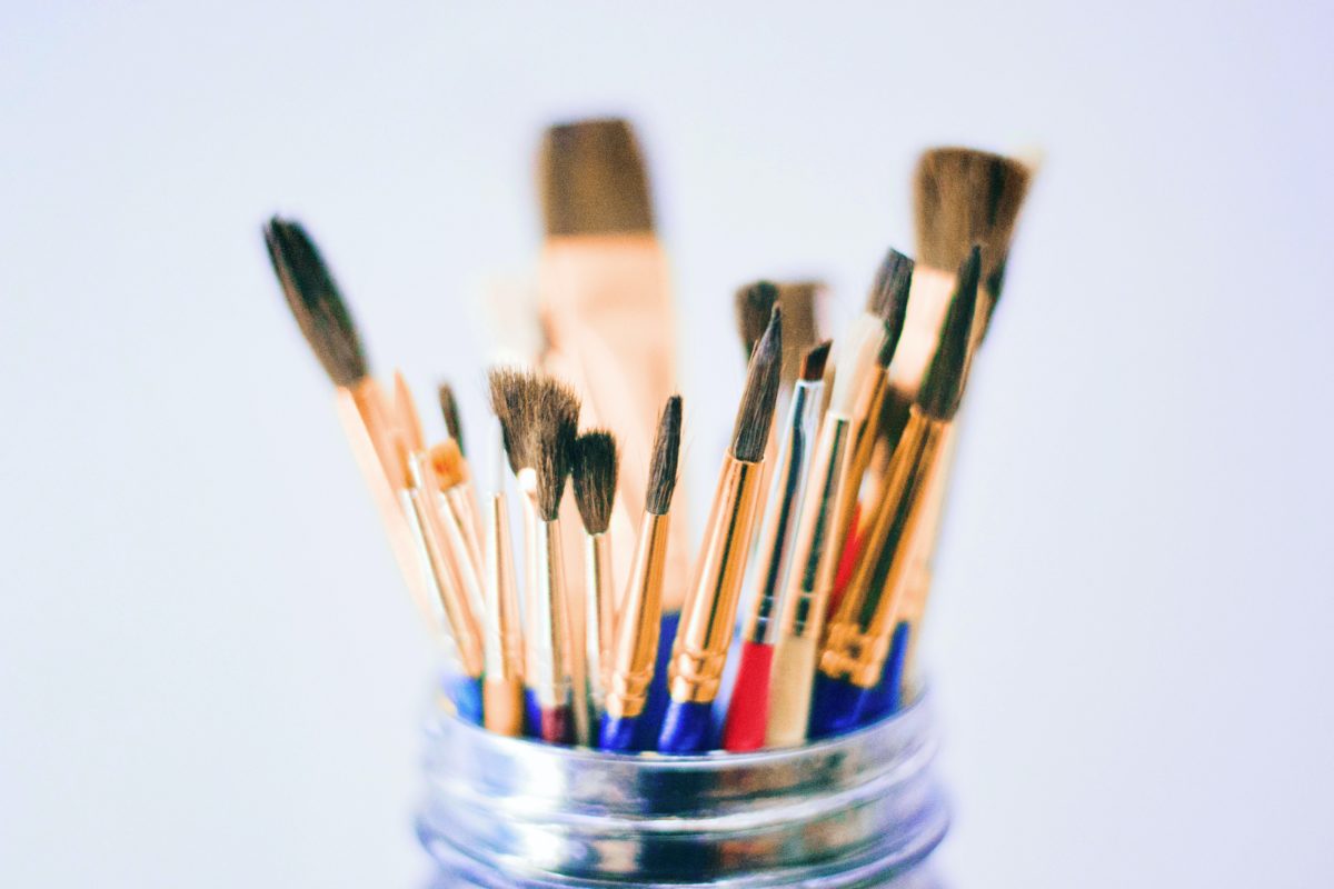 A pot filled with paint brushes