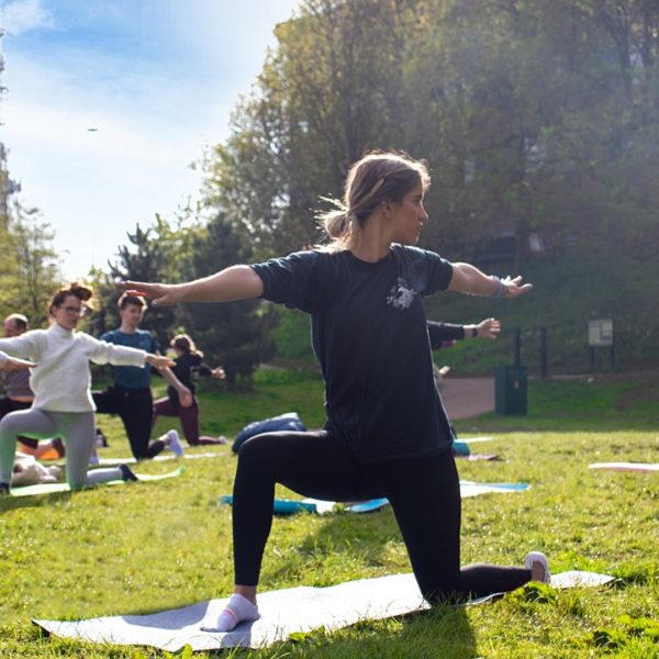 A yoga class takes place outside in a field.