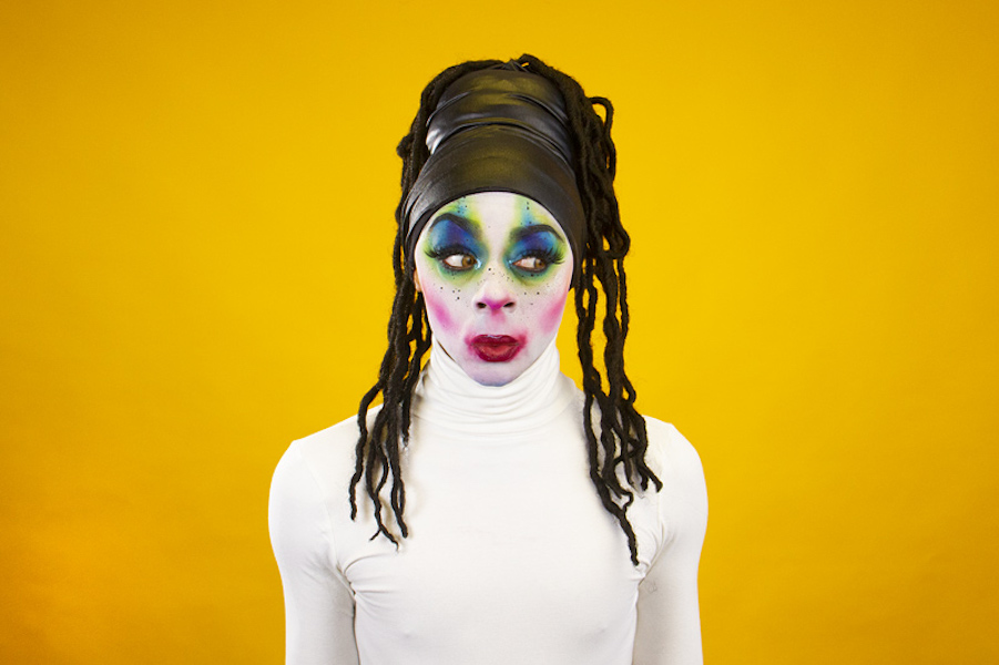 A performer at Vogue Ball stands against a yellow background.