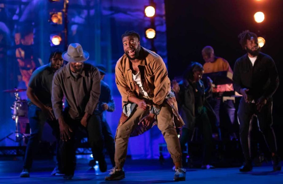 A performer stands on stage for a hip-hop and spoken word performance
