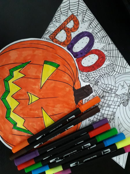 A brightly coloured picture of a pumpkin, a colouring in activity sheet and some felt tip pens.