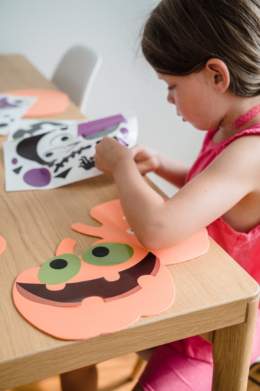 A small child enjoys a halloween craft activity.