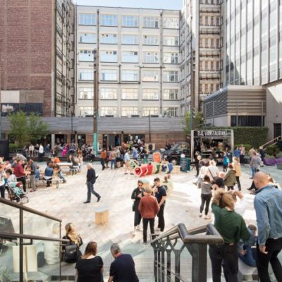 Lots of people walking around and meeting in Sadlers Yard, Manchester.