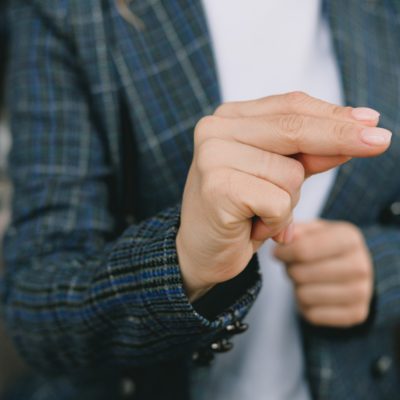 A person in a checked jacket using sign language.