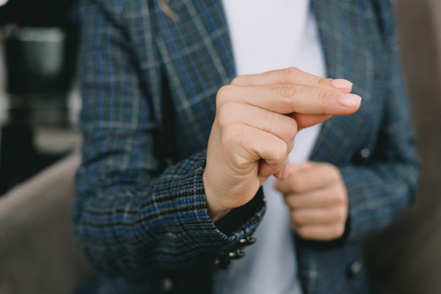 A person in a checked jacket using sign language.