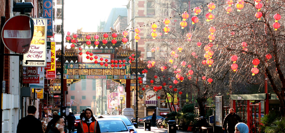 A street in Chinatown in Manchester, in the daytime, decorated with red lanterns.
