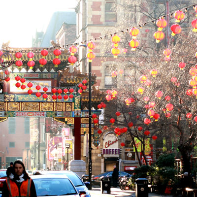 A street in Chinatown in Manchester, in the daytime, decorated with red lanterns.