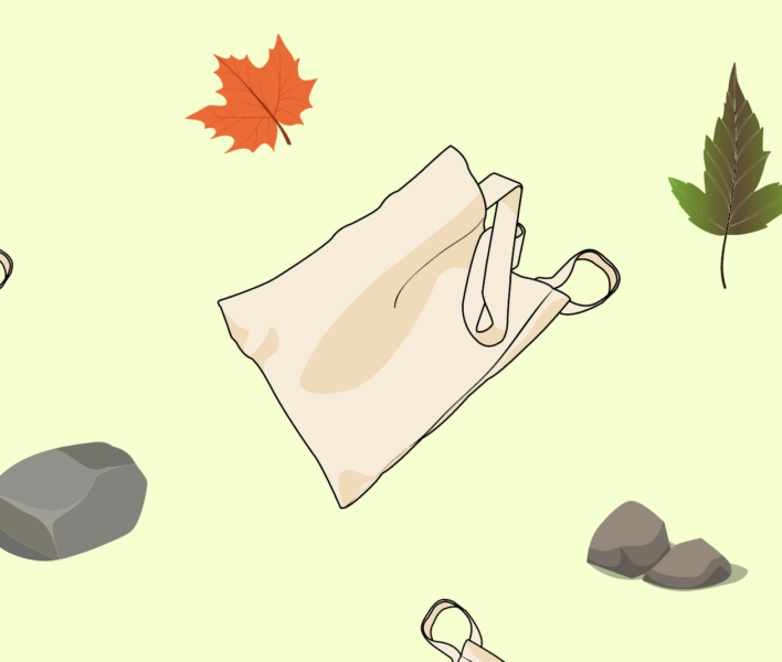 A tote bag blowing in the breeze surrounded by leaves.