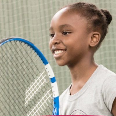 A young person holding a tennis racket