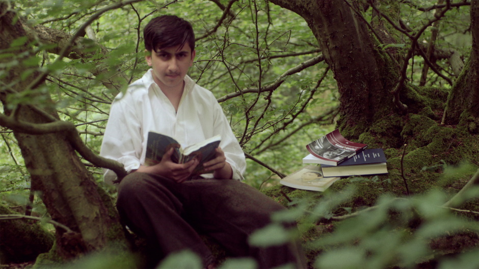 Juice Vamosi reads a book in a forest