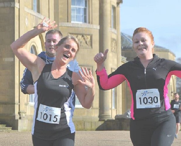 Three runners run past Heaton Hall
