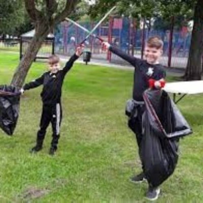 Two young people collecting litter