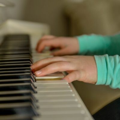 A young person's hands playing the piano