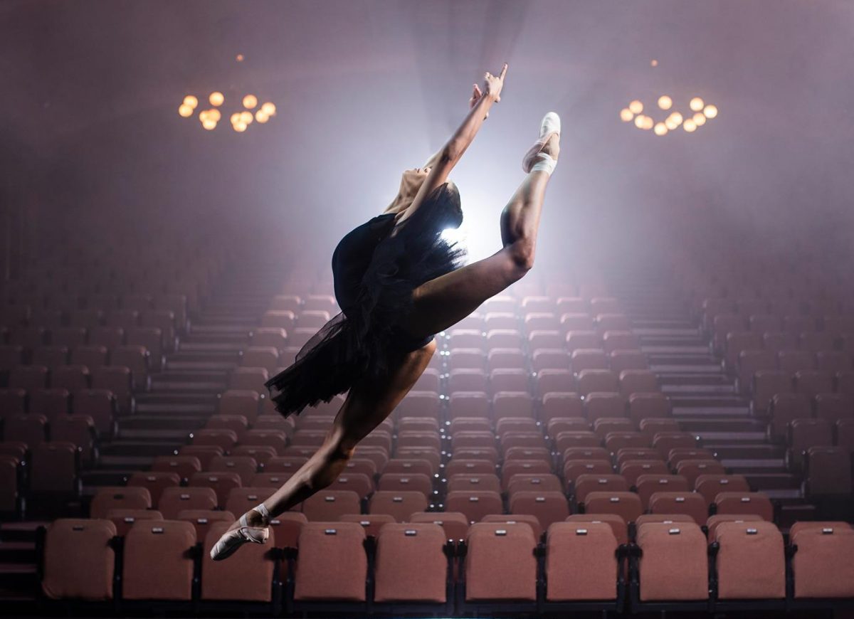 a ballet dancer performs a leap on stage