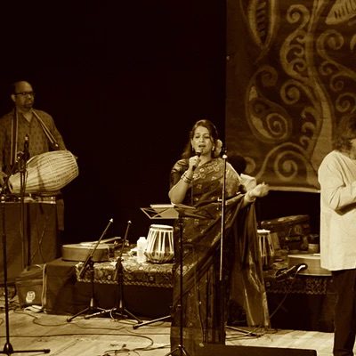 A performer sings into a microphone on stage