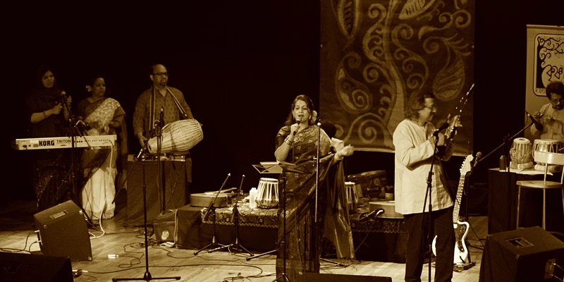 A performer sings into a microphone on stage