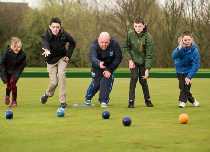 Five people play a game of bowls