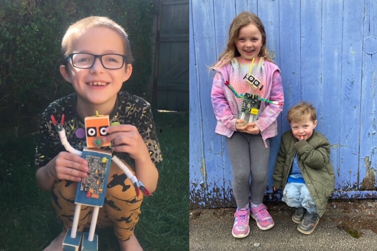 Two Children holding little robots