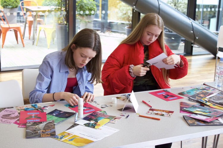 Two young people sit at a table and do craft activities