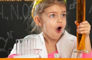 A young person holds a test tube and looks excited.