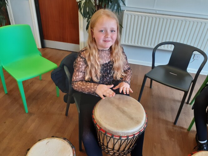 A child playing a hand drum
