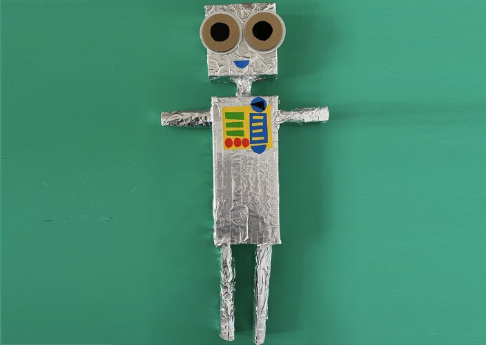 A silver junk model robot on a green background
